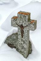 Cross with Jesus on tombstone in cemetery photo