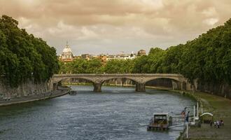 Bridge on the river Tiber and dome of St. Peter's Basilica in Rome, Italy photo