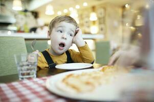 Young boy yawning as he waits to be fed photo