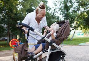 Granny playing with her grandson in pram photo