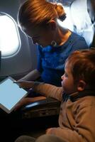 Mother traveling on a plane with her small son photo