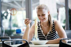 joven mujer comiendo espaguetis foto