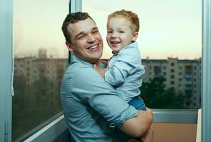 joven padre y hijo sonriente en el balcón. foto