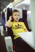 niño con auriculares en tren foto