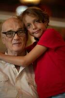 Child giving hugs to his grandpa photo