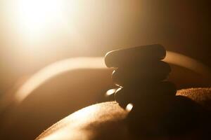 Girl taking hot stone treatments at beauty spa photo