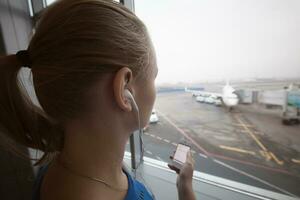 Woman in headphones looking at aiport area photo