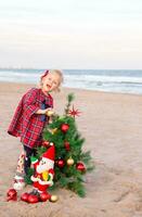 Christmas portrait of a toddler girl on the sea shore photo