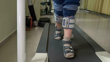 Child with foot drop system walking on the treadmill photo