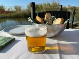 Cafe table with a glass of beer and bread photo