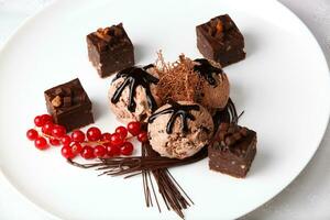 Chocolate ice cream with bonbons and red currants photo