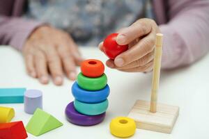 asiático mayor mujer jugando rompecabezas juego a práctica cerebro formación para demencia prevención, Alzheimer enfermedad. foto