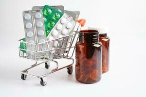 Shopping trolley with blister pill and capsule from drug prescription, pharmacy for treatment health medicine. photo