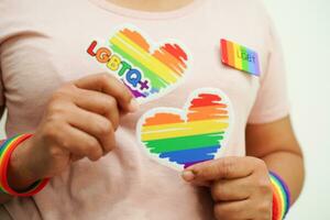 mujer asiática con bandera del arco iris, derechos de símbolos lgbt e igualdad de género, mes del orgullo lgbt en junio. foto