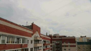 Cumulus clouds sky time lapse on the rails background with the roofs of houses in a residential area video