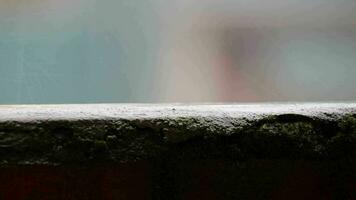 Raindrops dripping on the balcony railing. Roofs of houses in a residential area in the background. video