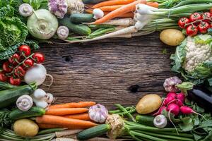 Assortment of fresh vegetables. Carrot garlic kohlrabi onion celery cucumber parsnip and radish on table. photo