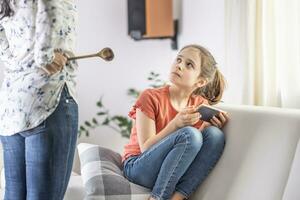 Mother-daughter disagreement with strict mother telling girl off for being online all the time photo