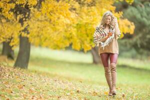 joven mujer en otoño atuendo emocional caminar en parque foto