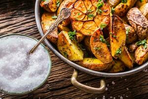 asado patatas con ajo especias sal comino y hierbas. foto