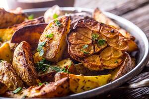 asado patatas con ajo especias sal comino y hierbas. foto