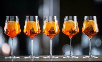 Summer sekt drink aperol spritz served in wine glasses with aperol, prosecco, soda and a slice of orange photo