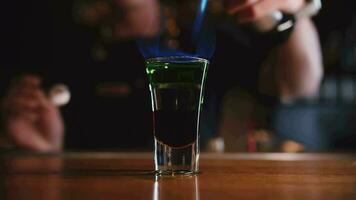 Barmann Rahmen Feuer zu ein alkoholisch Cocktail im ein Schuss Glas video
