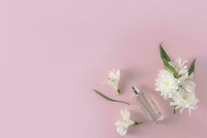 un elegante botella de perfume o eau Delaware baño en un pastel antecedentes con primavera flores parte superior vista. un Copiar espacio. presentación de el fragancia. foto