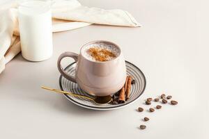 Large ceramic mug with aromatic coffee latte, cinnamon cappuccino. coffee beans. cinnamon sticks. A bottle of milk. still life. photo