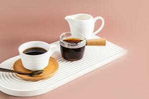 un pequeño taza de Mañana Café exprés café en un bandeja en el formar de un arco con un cezve con recién elaborada café y un jarra de leche. frente vista. foto