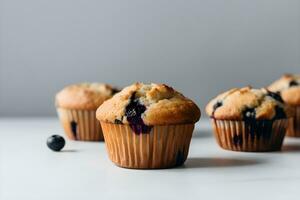Blueberry muffins with fresh blueberries on a white table, close up, light background. A delicious dessert or breakfast. AI generated. photo