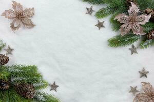 Christmas fir tree branches flat lay with pine cones and decoration on snow background. Creative composition with border. Top view. Copy space. photo