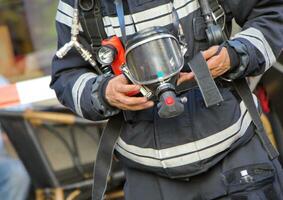 Firefighter holding oxygen or gas mask photo