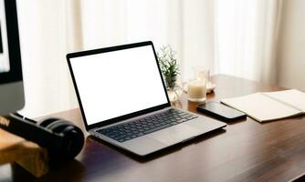 Laptop with blank screen on wooden table photo