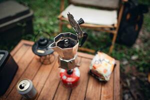 Moka pot coffee on outdoor camping table photo