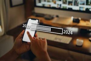 nuevo año 2024 celebracion concepto, teléfono inteligente y trabajo escritorio a hogar antecedentes foto