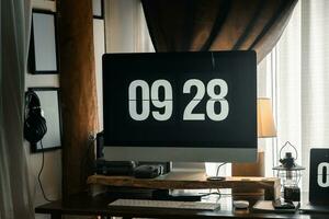 Home computer desk and digital clock on screen photo