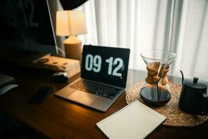 Home computer desk and digital clock on screen photo