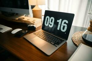 Home computer desk and digital clock on screen photo