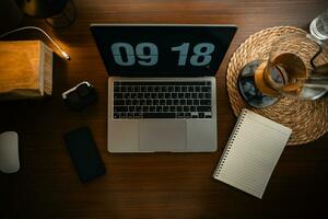 Home computer desk and digital clock on screen photo