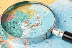 Bangkok, Thailand  January 20, 2022 Japan, Magnifying glass close up with colorful world map, travel, geography, tourism and exploration concept. photo