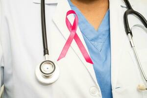 Breast cancer, Asian doctor woman with pink ribbon, symbol of World Breast Cancer Day. photo