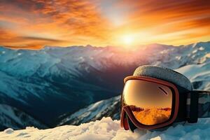 Goggles for winter sports on the top of a mountain in the sunset. Beautiful sunset in the mountains in winter photo