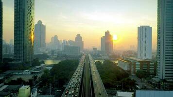 There is a flying shot over the river in the form of a bridge with cars and a wonderful and beautiful sunset . Aerial view of an important landmark bridge, traffic and land transportation video