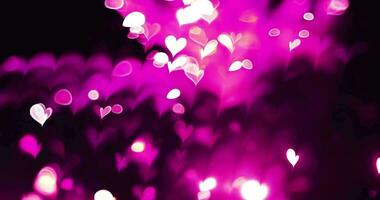 rosa colore amore cuore raggiante bokeh effetto su nero sfondo. romantico astratto movimento sfondo. video
