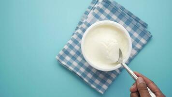 spoon pick fresh yogurt in a bowl on table video