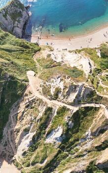 People at Most Beautiful High Angle View of British Landscape and Sea View of Durdle Door Beach of England Great Britain, UK. Image Was captured with Drone's camera on September 9th, 2023 photo