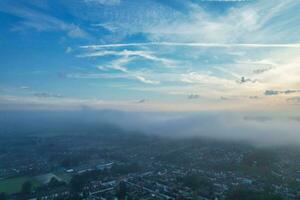 Most Beautiful and Best High Angle Dramatical Colourful Sky Footage from Above The Clouds. The Fast Moving Clouds During Sun rising Early in the Morning over Luton City of England UK photo