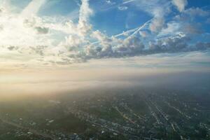 Most Beautiful and Best High Angle Dramatical Colourful Sky Footage from Above The Clouds. The Fast Moving Clouds During Sun rising Early in the Morning over Luton City of England UK photo