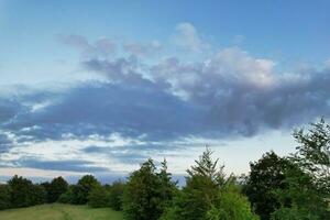 Most Beautiful High Angle view of Dramatical Sky and Clouds over British Countryside Landscape During Sunset photo